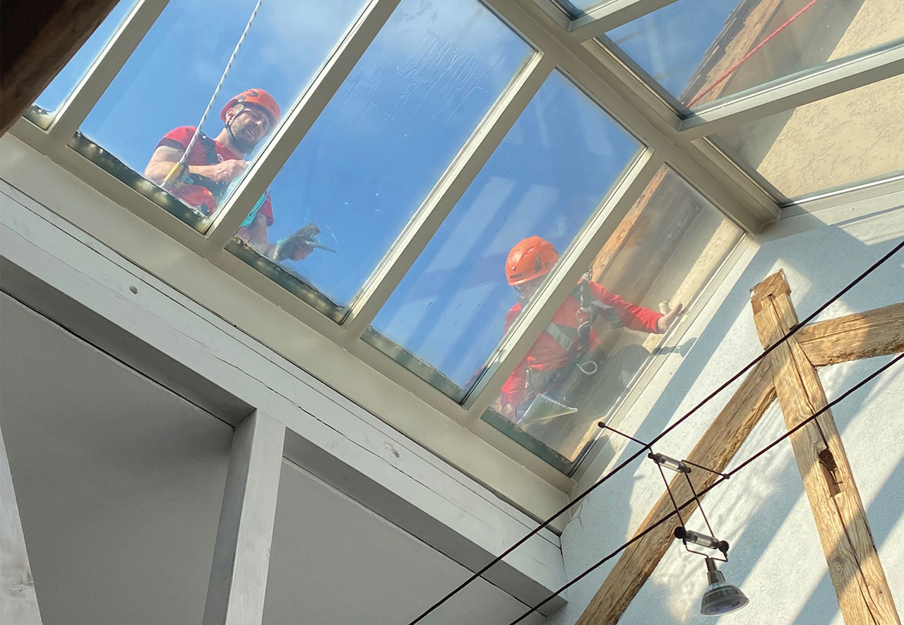 Arbeiter montieren Folie auf Glasdach der Villa in Lenzburg