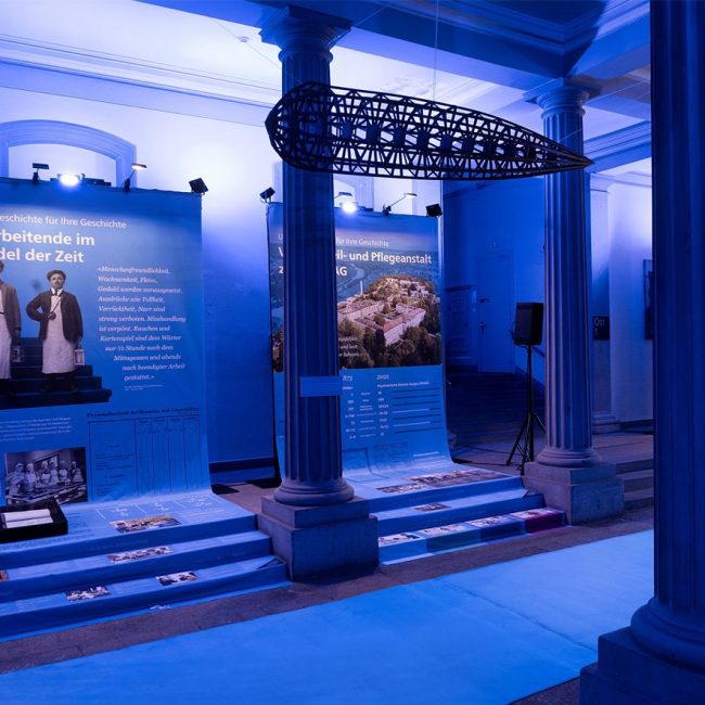 Blau beleuchteter Raum mit historischer Ausstellung